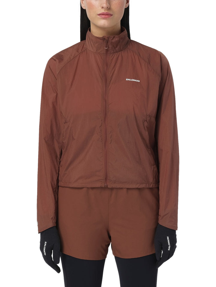 Chaqueta deportiva Salomon Shakeout Fly en color Burnt Umber con cierre frontal y cuello alto.