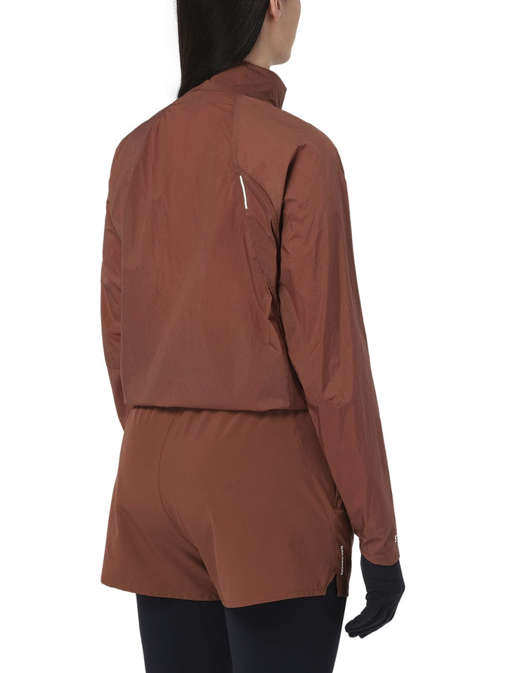 Chaqueta deportiva Salomon Shakeout Fly en color Burnt Umber con cierre frontal y cuello alto.