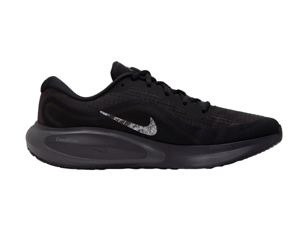 Tenis Nike Journey Run en color negro con suela ComfiRide y logotipo lateral en tonos grises y blancos.