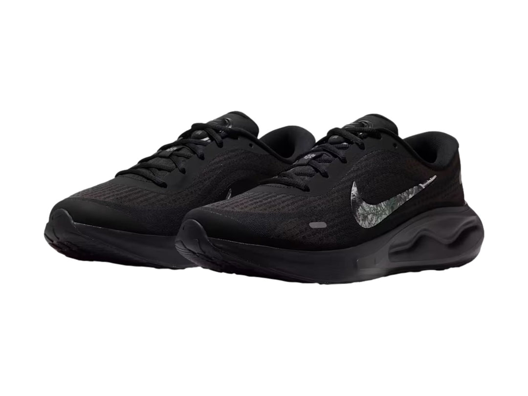 Tenis Nike Journey Run en color negro con suela ComfiRide y logotipo lateral en tonos grises y blancos.