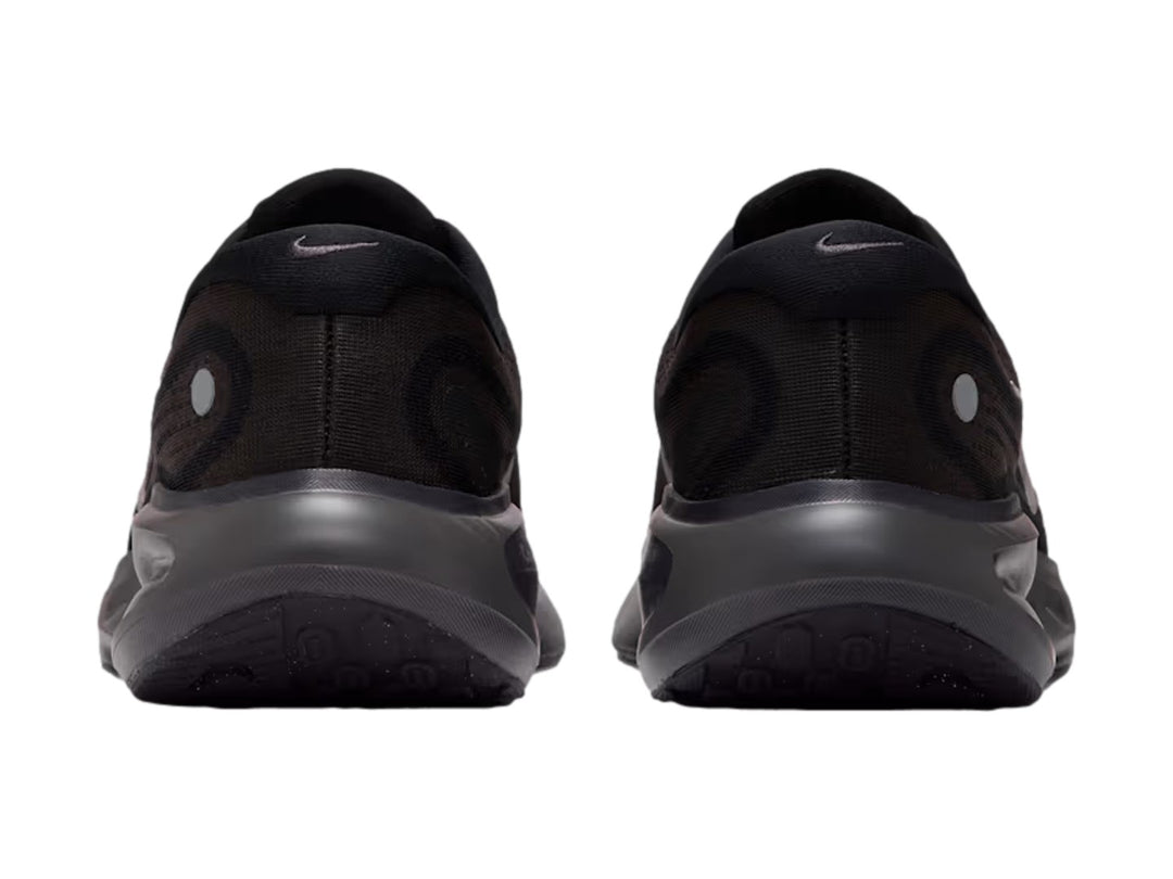 Tenis Nike Journey Run en color negro con suela ComfiRide y logotipo lateral en tonos grises y blancos.