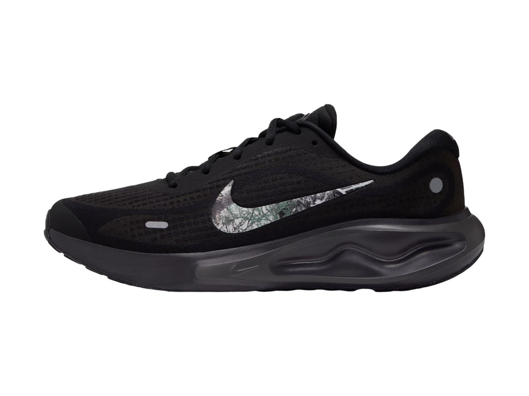 Tenis Nike Journey Run en color negro con suela ComfiRide y logotipo lateral en tonos grises y blancos.
