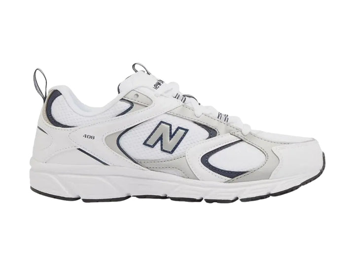 Tenis New Balance 408 color blanco con detalles en gris y azul marino, vista lateral sobre fondo blanco.