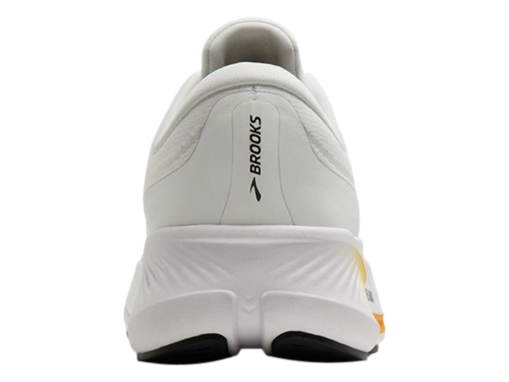 Tenis Brooks Revel Max en color blanco con detalles en naranja y negro, vista lateral sobre fondo blanco.